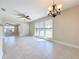 Bright living room has tile floors, ceiling fan, chandelier, and many windows at 21402 Meehan Ave, Port Charlotte, FL 33952