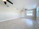 Spacious living room featuring tiled floors, neutral walls, and two ceiling fans and natural light at 21402 Meehan Ave, Port Charlotte, FL 33952