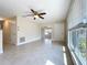 Open living room features tile floors, ceiling fan, and large window with natural light at 21402 Meehan Ave, Port Charlotte, FL 33952