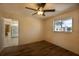 The bedroom features a ceiling fan, window overlooking neighborhood, and wood-look flooring at 2275 Logsdon St, North Port, FL 34287