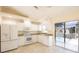 Modern kitchen with white appliances, light countertops, and a view to the pool area at 2275 Logsdon St, North Port, FL 34287