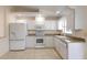 Well-lit kitchen featuring granite countertops, white appliances and ample cabinet space at 2275 Logsdon St, North Port, FL 34287