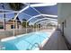 Covered pool boasts crystal clear water, tile flooring and relaxing spot to unwind at 2275 Logsdon St, North Port, FL 34287