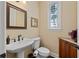 Elegant powder room with pedestal sink and wood vanity at 24248 Treasure Island Blvd, Punta Gorda, FL 33955