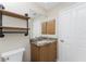 Bathroom features stylish industrial pipe shelving and granite countertop with wood cabinets at 24343 Pirate Harbor Blvd, Punta Gorda, FL 33955