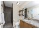 Bathroom with stone tiled walk-in shower, industrial pipe shelving and granite vanity at 24343 Pirate Harbor Blvd, Punta Gorda, FL 33955