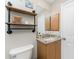 Bathroom features stylish industrial pipe shelving and granite countertop with wood cabinets at 24343 Pirate Harbor Blvd, Punta Gorda, FL 33955