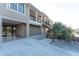 Exterior view of elevated home with beige siding, wooden stairs, and an open garage area with access to the canal at 24343 Pirate Harbor Blvd, Punta Gorda, FL 33955