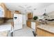 Bright kitchen with wooden cabinetry, granite countertops, white appliances, and tiled flooring at 24343 Pirate Harbor Blvd, Punta Gorda, FL 33955