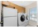 Convenient laundry room with a full-size washer, dryer, extra refrigerator and storage cabinets at 24343 Pirate Harbor Blvd, Punta Gorda, FL 33955