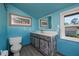 Bathroom with light blue walls, a vanity, and a toilet at 28094 Chinquapin Dr, Punta Gorda, FL 33955