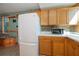 Kitchen area with wood cabinets, white appliances, and tile backsplash at 28094 Chinquapin Dr, Punta Gorda, FL 33955