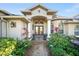 Inviting front entrance with double doors, manicured landscaping and covered entry way with decorative pillars at 290 Rotonda E Blvd, Rotonda West, FL 33947