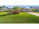 Beautiful home featuring a pristine lawn, mature palm trees, and a two-car garage at 290 Rotonda E Blvd, Rotonda West, FL 33947