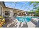 Inviting screened-in pool with patio furniture and lush tropical landscaping surrounding the area at 290 Rotonda E Blvd, Rotonda West, FL 33947