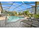 Sparkling pool inside a screened enclosure, surrounded by patio seating and mature landscaping at 290 Rotonda E Blvd, Rotonda West, FL 33947