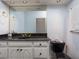 Bathroom with granite countertop, white vanity, and black toilet at 298 Fry Se Ter, Port Charlotte, FL 33952