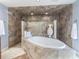 Elegant bathroom with soaking tub, walk-in shower, and stone tile at 298 Fry Se Ter, Port Charlotte, FL 33952