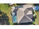 An aerial view of a home with a screened pool, solar panels, and lush landscaping at 336 Japura St, Punta Gorda, FL 33983