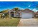 Inviting home showcasing a blue front door, lush landscaping, and an attached two-car garage at 336 Japura St, Punta Gorda, FL 33983