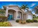 Welcoming front entrance with a vibrant blue double door, arched entryway, and lush tropical landscaping at 336 Japura St, Punta Gorda, FL 33983