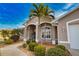 Close-up showcasing the front entrance with a blue door, palm trees, and lush, landscaped surroundings at 336 Japura St, Punta Gorda, FL 33983