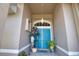 Close-up view of the double front door with decorative wreath, plants, and tiled porch at 336 Japura St, Punta Gorda, FL 33983