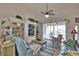 Living room featuring a ceiling fan, a built-in bookcase, and access to the outdoor patio at 336 Japura St, Punta Gorda, FL 33983