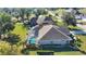 Backyard view of a home with a screened pool enclosure, lush landscaping, and a well-manicured lawn at 336 Japura St, Punta Gorda, FL 33983