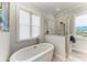 Bathroom featuring a soaking tub, walk-in shower with glass enclosure, and a bright window at 37 Bocilla Dr, Placida, FL 33946