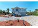 Charming coastal home features landscaping, statue, and a cozy white stair entrance at 37 Bocilla Dr, Placida, FL 33946