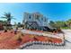 Charming coastal home with tidy landscaping, statue, and a cozy white stair entrance at 37 Bocilla Dr, Placida, FL 33946