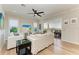 Bright living room with stylish white furniture, and views of the water from the sliding door at 37 Bocilla Dr, Placida, FL 33946