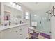 Bright bathroom featuring a double sink vanity, walk-in shower, subway tile, and a view into the walk-in closet at 3871 Bordeaux Dr, Punta Gorda, FL 33950