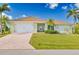 Charming single-story home with a tile roof, two-car garage, well manicured lawn, and mature palm trees at 3871 Bordeaux Dr, Punta Gorda, FL 33950