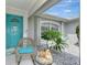 Inviting front porch with teal door and cozy seating area at 4059 Twinbush Ter, North Port, FL 34286