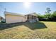 View of the home's backyard featuring a screened lanai, lush lawn, and a storage shed at 4355 Boggs St, Port Charlotte, FL 33948