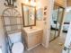 Bright bathroom showcasing vanity, toilet, decorative shelving and view of the primary bedroom at 4355 Boggs St, Port Charlotte, FL 33948