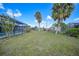 Spacious backyard with lush grass and palm trees at 4415 Mundella Cir, Port Charlotte, FL 33948