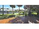 Backyard with a wooden deck, lush landscaping, and a boat dock on a sunny, palm tree-lined canal at 4542 Fallon Cir, Port Charlotte, FL 33948