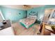 Bright bedroom with light blue walls, wood-look floors, and tropical-themed decor at 4542 Fallon Cir, Port Charlotte, FL 33948