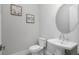 Stylish powder room with pedestal sink and round mirror at 500 Blue Shell Loop, Sarasota, FL 34240