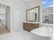 Spa-like bathroom with soaking tub, walk-in shower, and modern vanity at 500 Blue Shell Loop, Sarasota, FL 34240