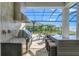 Outdoor kitchen with stainless steel appliances and granite countertops, overlooking pool and water at 500 Blue Shell Loop, Sarasota, FL 34240