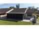 Exterior view of the home with a screened lanai and patio overlooking the backyard at 5688 Mashie Cir, North Port, FL 34287