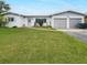 Ranch style home with a two car garage and a well manicured lawn at 625 Pompano Ter, Punta Gorda, FL 33950