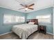 Comfortable bedroom features wood-look flooring, a ceiling fan, and a neutral color scheme at 6835 Anapa Ct, North Port, FL 34287