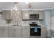 Bright kitchen area with modern appliances and gray cabinetry at 6835 Anapa Ct, North Port, FL 34287