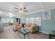 Comfortable living room featuring cozy furniture, a ceiling fan, and a view into the kitchen at 6835 Anapa Ct, North Port, FL 34287