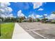 Parking area leading to community building featuring tennis and shuffleboard courts at 7325 Mikasa Dr, Punta Gorda, FL 33950